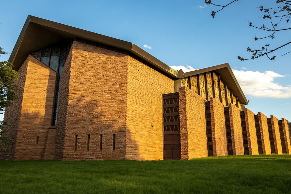 A modern brick building with a curved roof and large windows.