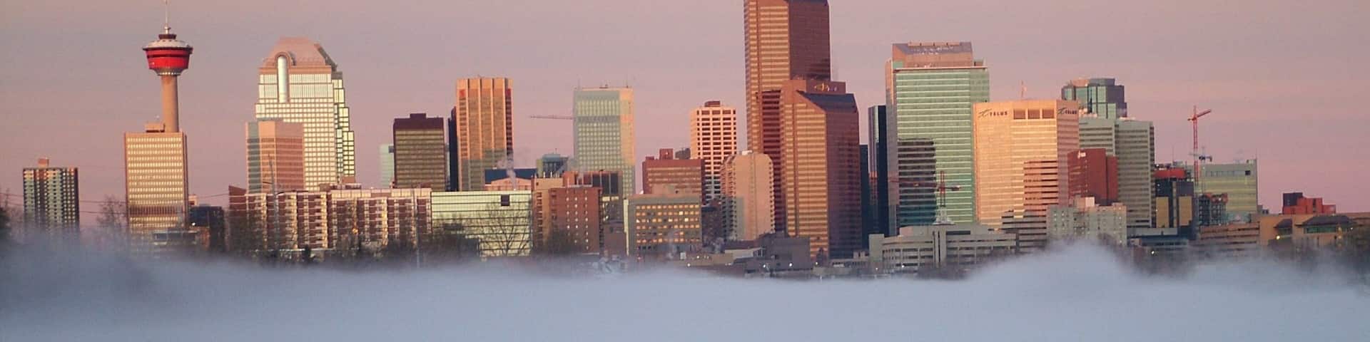 A city skyline with a prominent tower and modern buildings.
