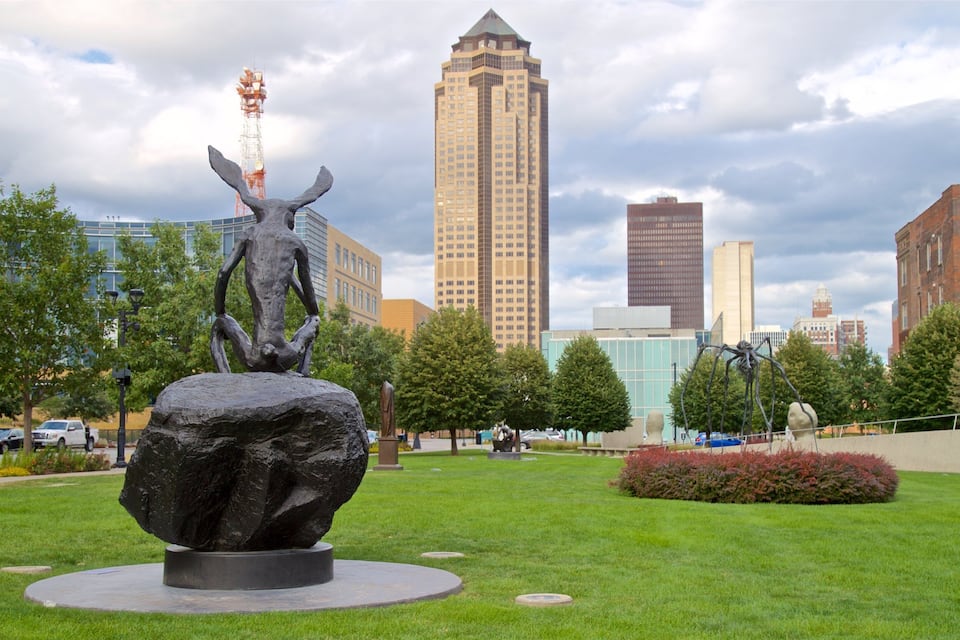 A sculpture of a bull in a park with a city skyline in the background.
