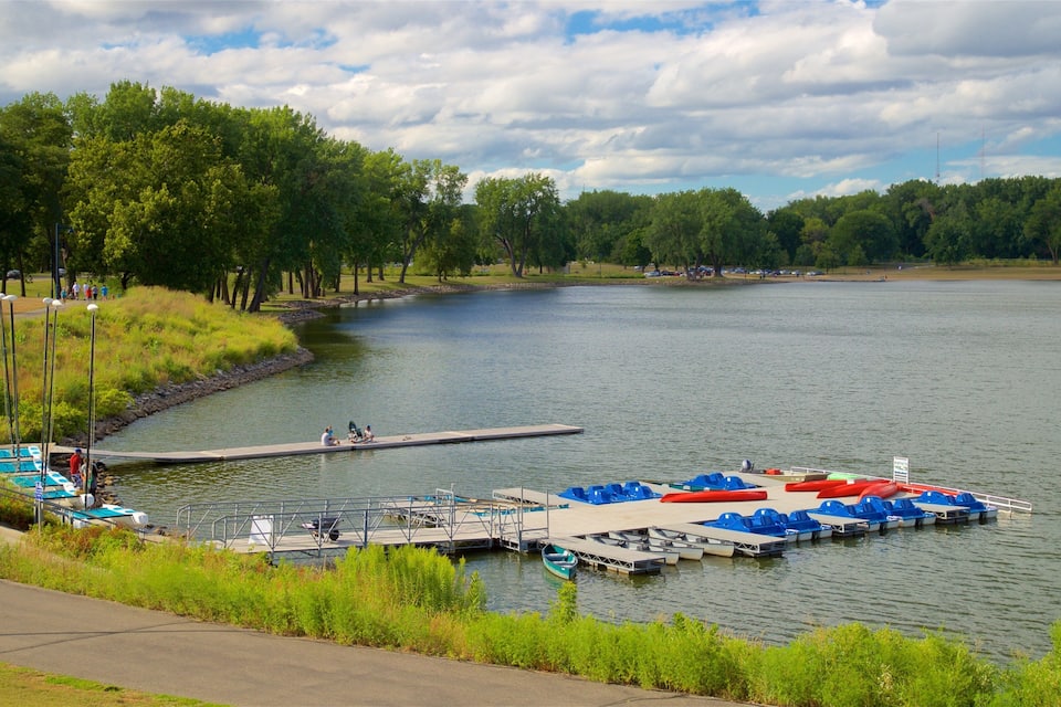 A lakeside park with docks, boats, and a walking path.