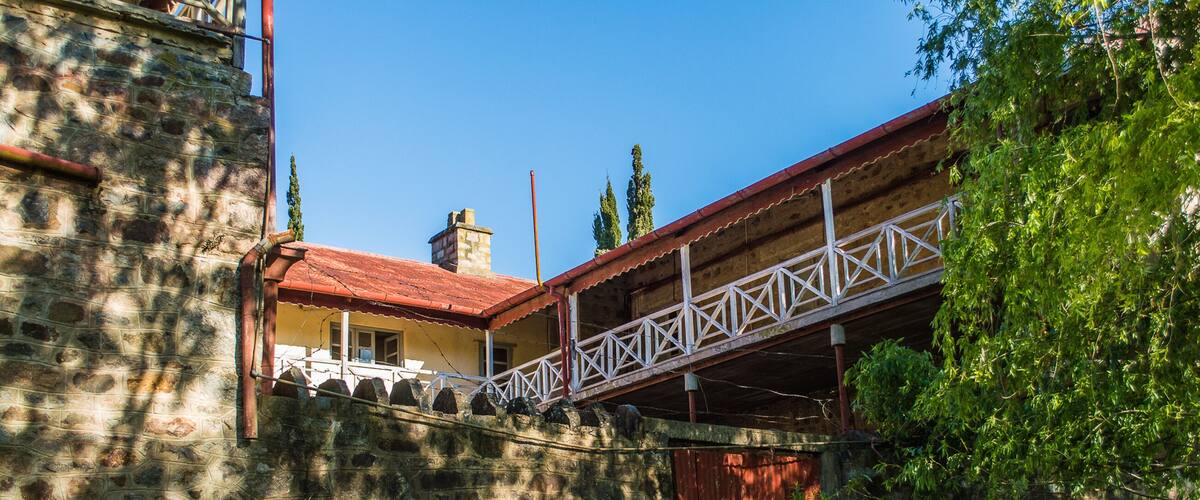 A stone wall, a red-roofed building, and a white bridge.