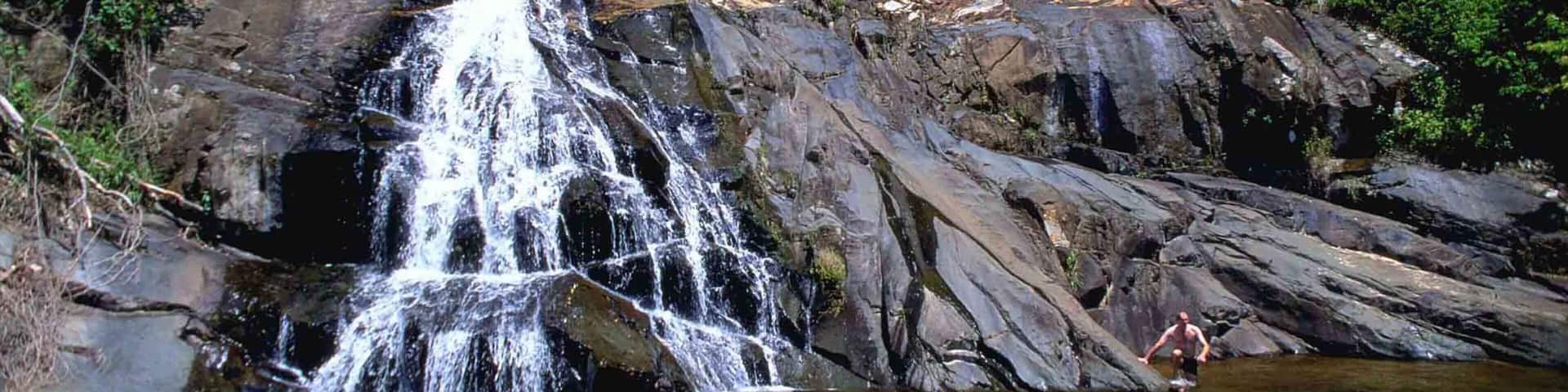 Magoebaskloof which includes a waterfall and swimming as well as a small group of people