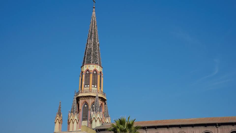 A church tower with a pointed spire and ornate decorations.