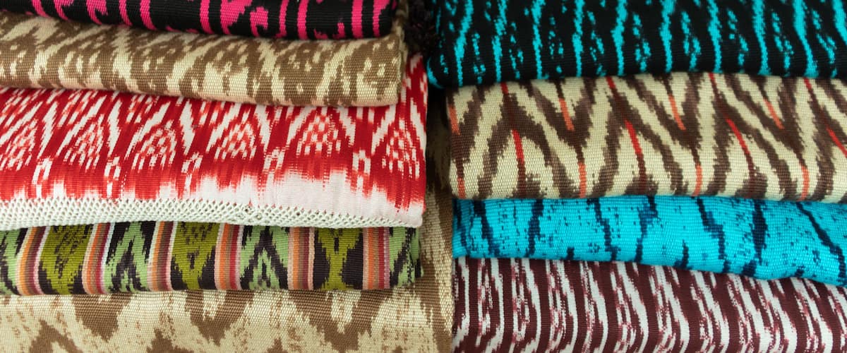 Scarves or Macanas at the market, traditional handcraft and design for Gualaceo canton, Azuay province, made by using technique called Ikat, colorful fabrics background. Cuenca, Ecuador