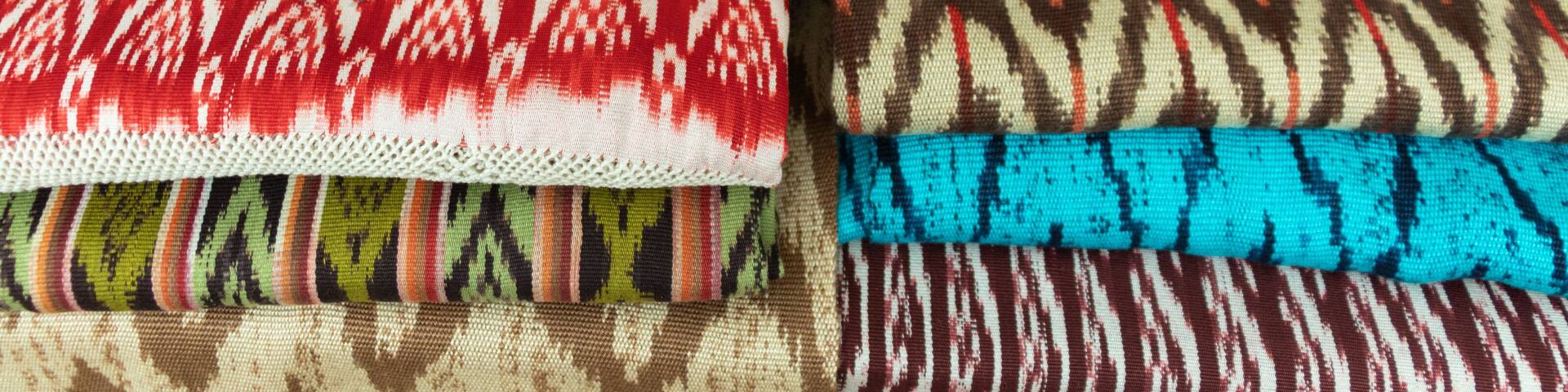 Scarves or Macanas at the market, traditional handcraft and design for Gualaceo canton, Azuay province, made by using technique called Ikat, colorful fabrics background. Cuenca, Ecuador
