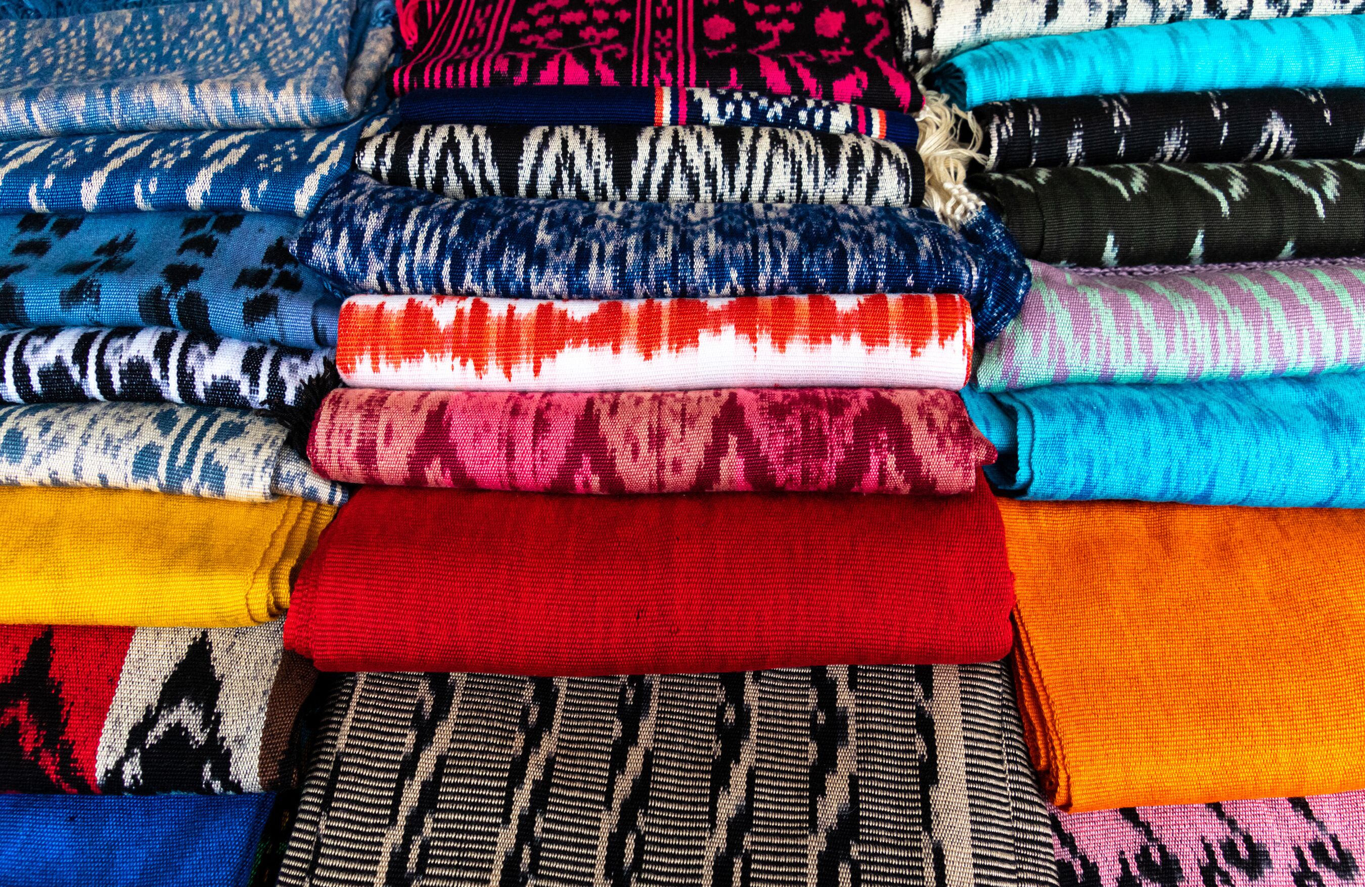 Scarves or Macanas at the market, traditional handcraft and design for Gualaceo canton, Azuay province, made by using technique called Ikat, colorful fabrics background. Cuenca, Ecuador	