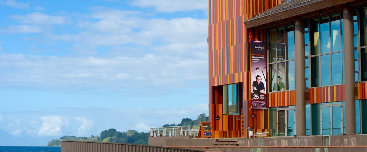 A waterfront building with a colorful facade and large windows overlooking the water.