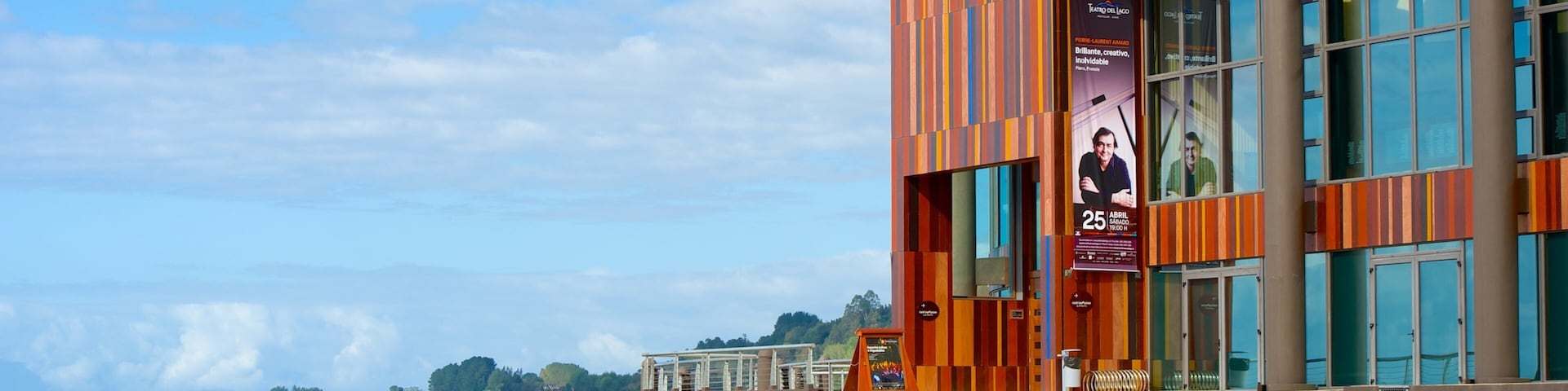 A waterfront building with a colorful facade and large windows overlooking the water.