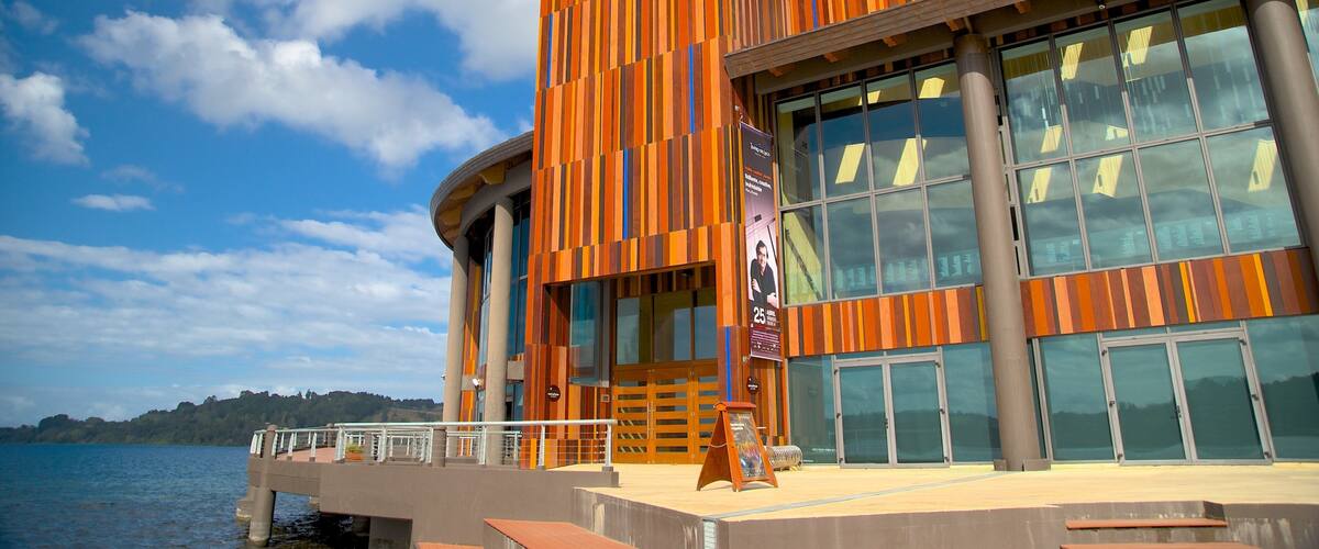 A modern building with a striped facade, large windows, and a view of the water.