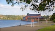 A lakeside view with a wooden building and a dock extending into the water.