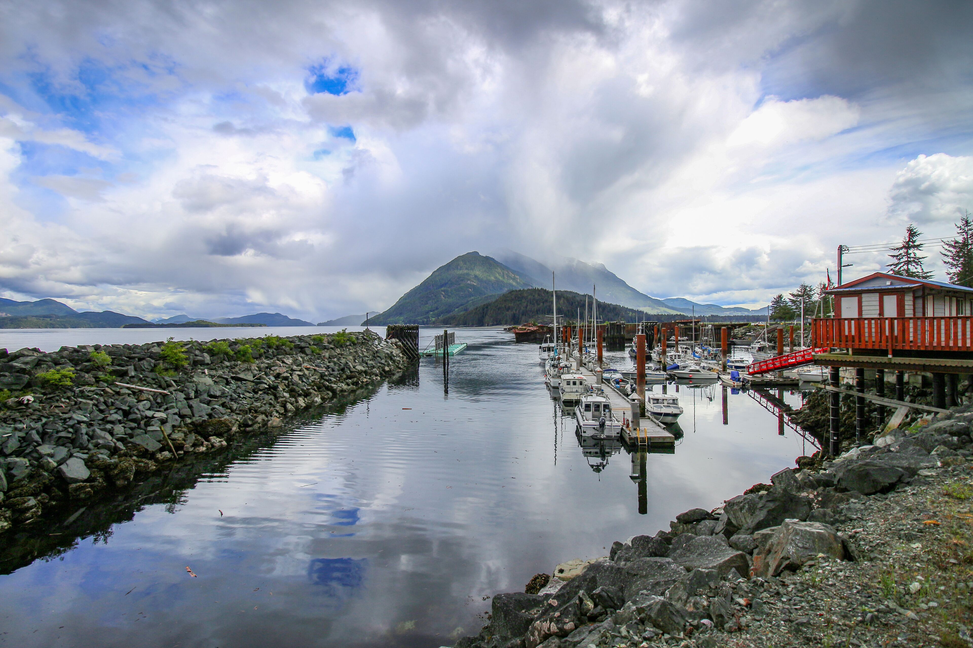 Kelsey Bay - north shore of Vancouver Island, BC. The view on the harbour, boats, rocks, pier and mountains in the background.