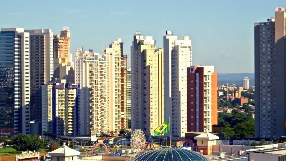 A cityscape with tall buildings, a Ferris wheel, and a McDonald's sign.