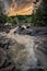 A fast-flowing river with rocky terrain and dense forest.
