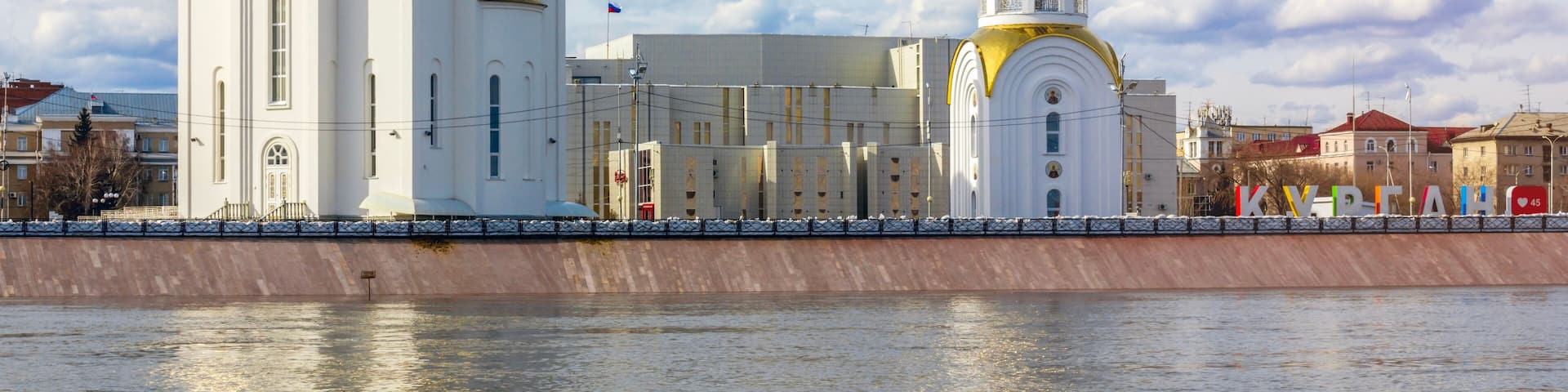 The view of the Tobol River and Holy Trinity Church in Kurgan, Russia.