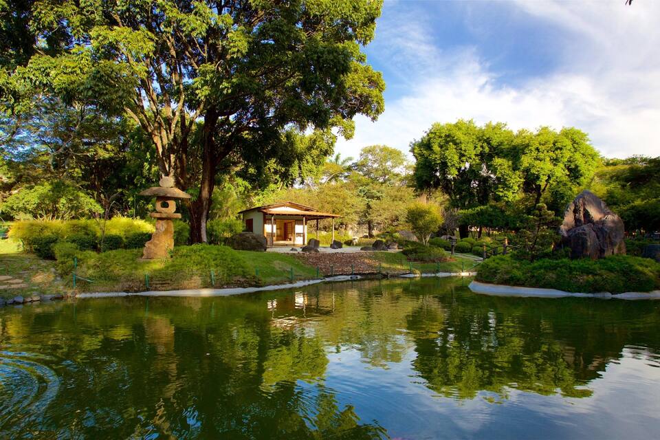 A tranquil garden with a pond, a traditional Japanese torii gate, and a small pavilion.