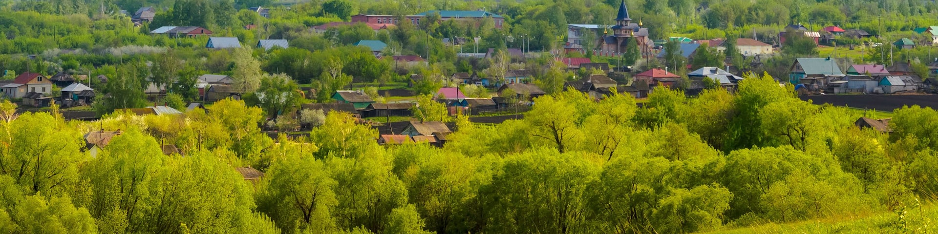 Panoramic view of Inzhavino village in Voroninsky National Park, Tambov Oblast, Russia. River, trees and the field on a sunny summer day.