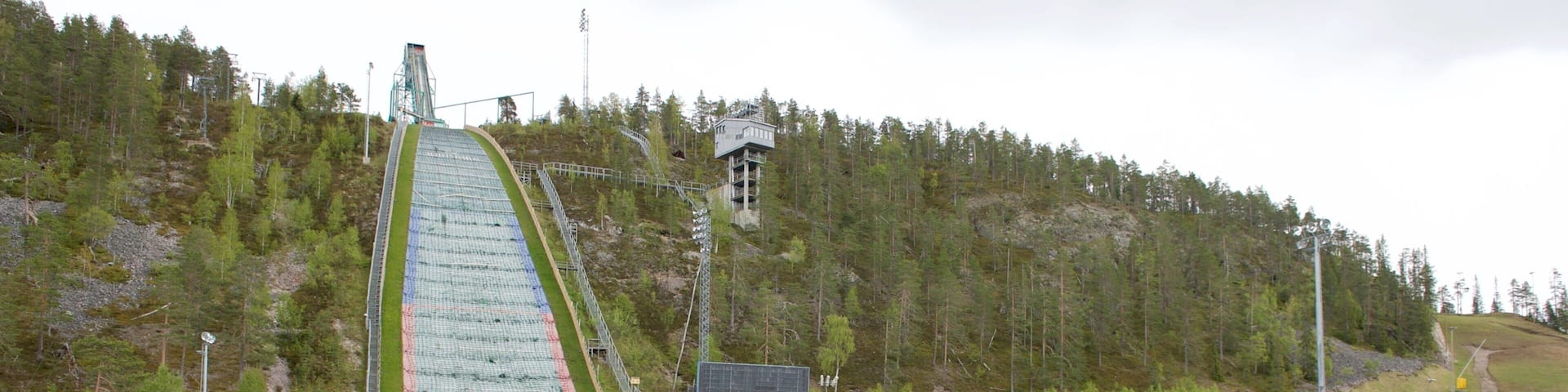 A ski jump with a long, steep slope and a viewing platform at the top.