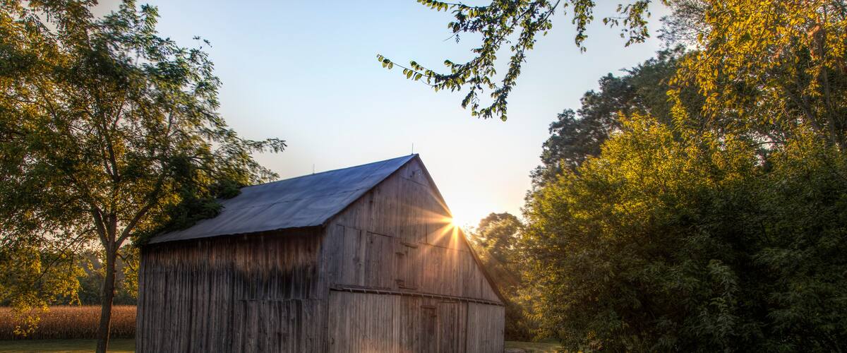 Sunlight burst through the roof a barn on a Autumn evening in Perry County, Missouri