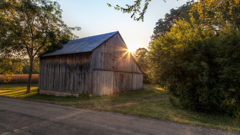 Sunlight burst through the roof a barn on a Autumn evening in Perry County, Missouri