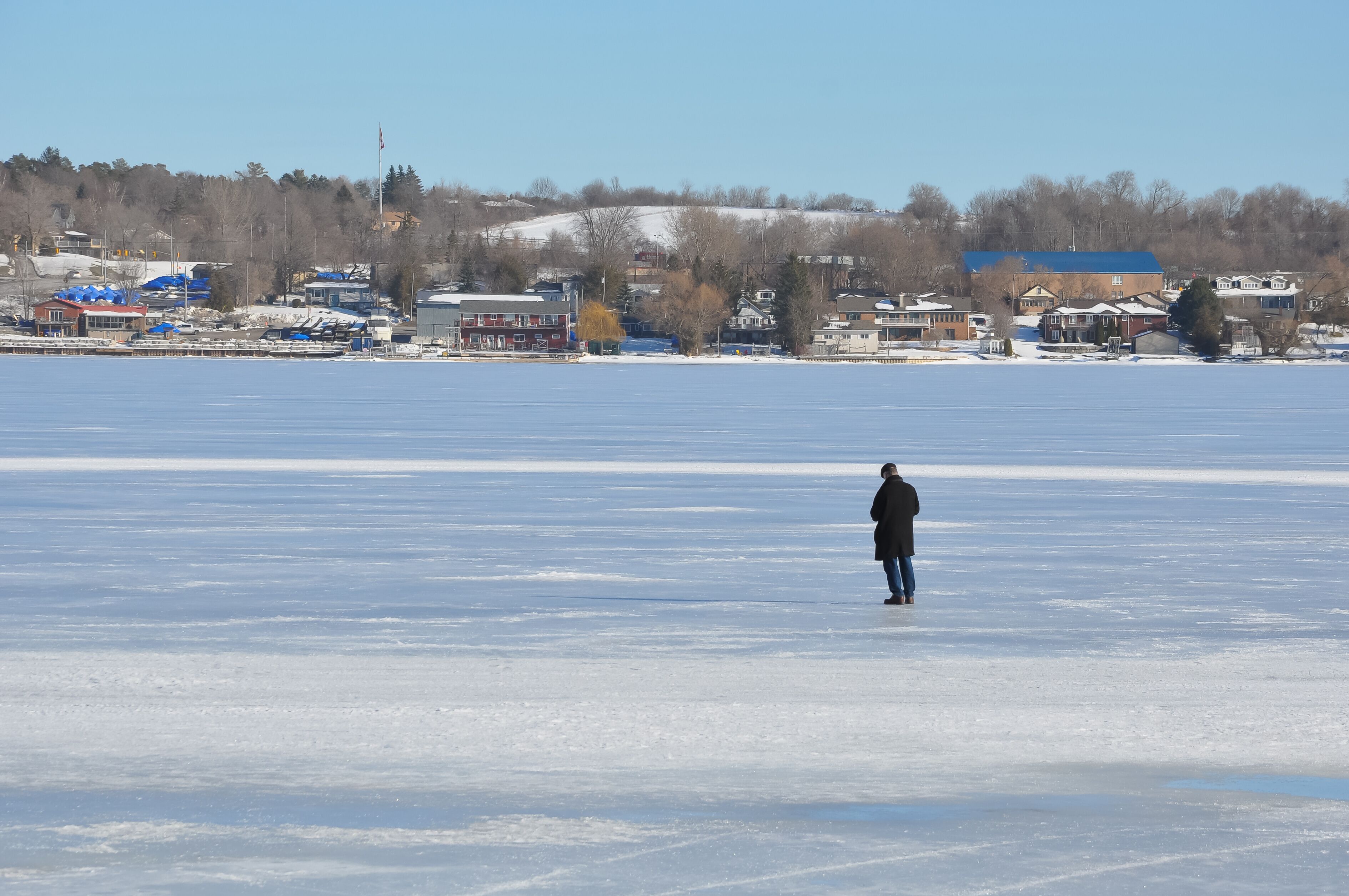 Back view of a person standing alone in a frozen lake