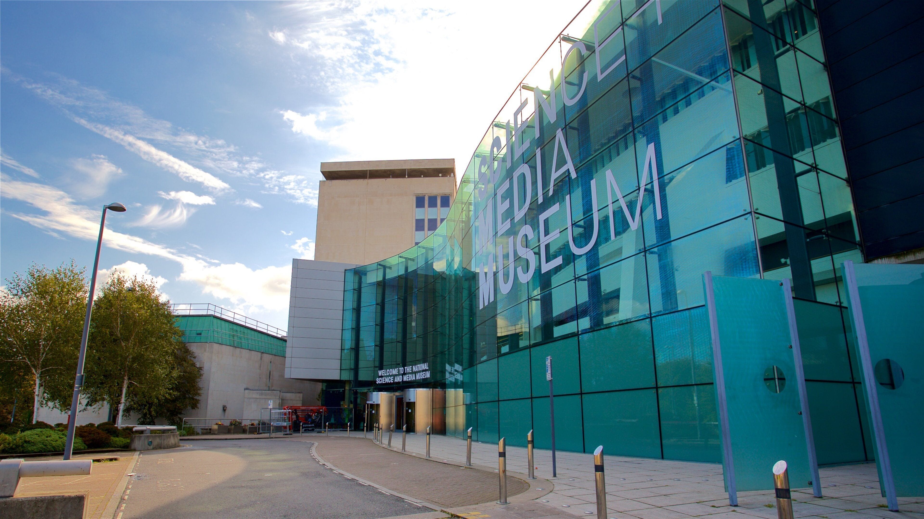 The exterior of the Science and Media Museum with a glass facade and a clear sky.