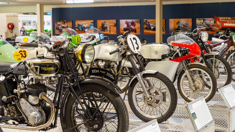 A collection of vintage motorcycles on display in a museum.