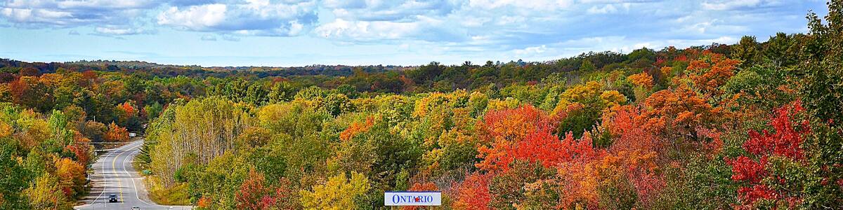 Milford Bay, Ontario / Canada - 10/05/2008: Mountain road. Landscape with rocks, autumn leaf color, and beautiful asphalt road in autumn. High angle view....