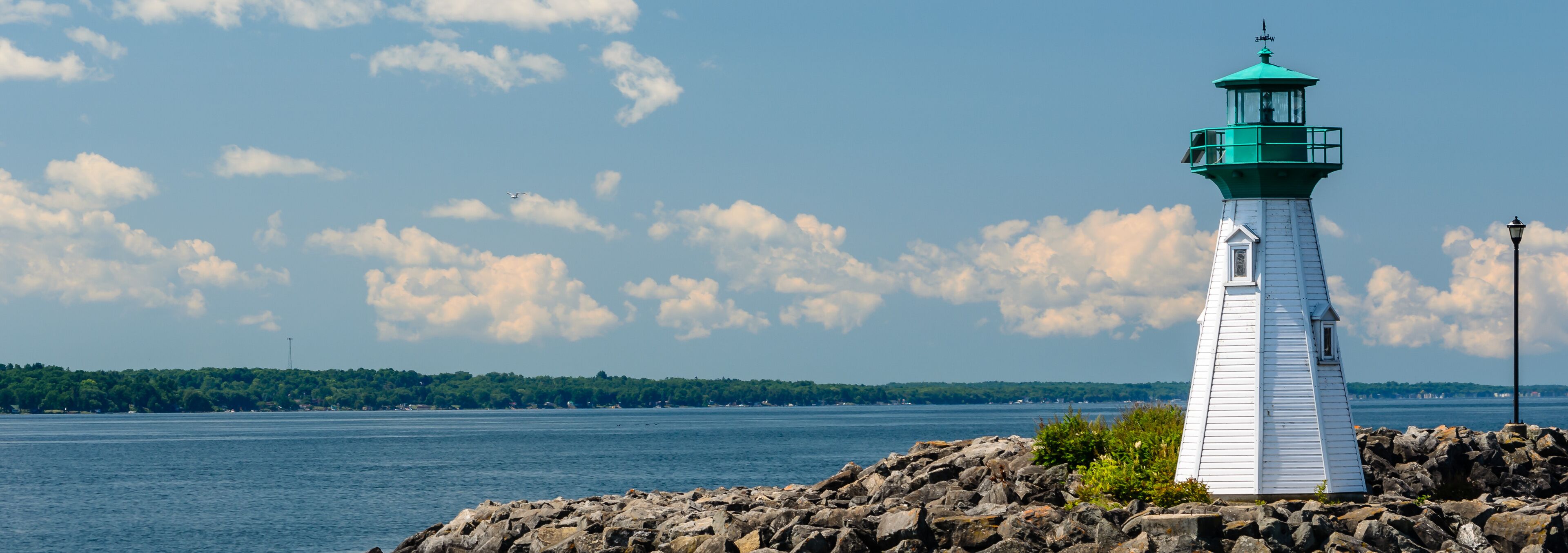 White and green Harbour lighthouse on the breakwater overloking the St. Lawrence River