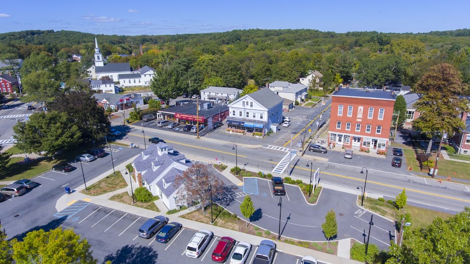 A town with a church, a blue building, and a parking lot.