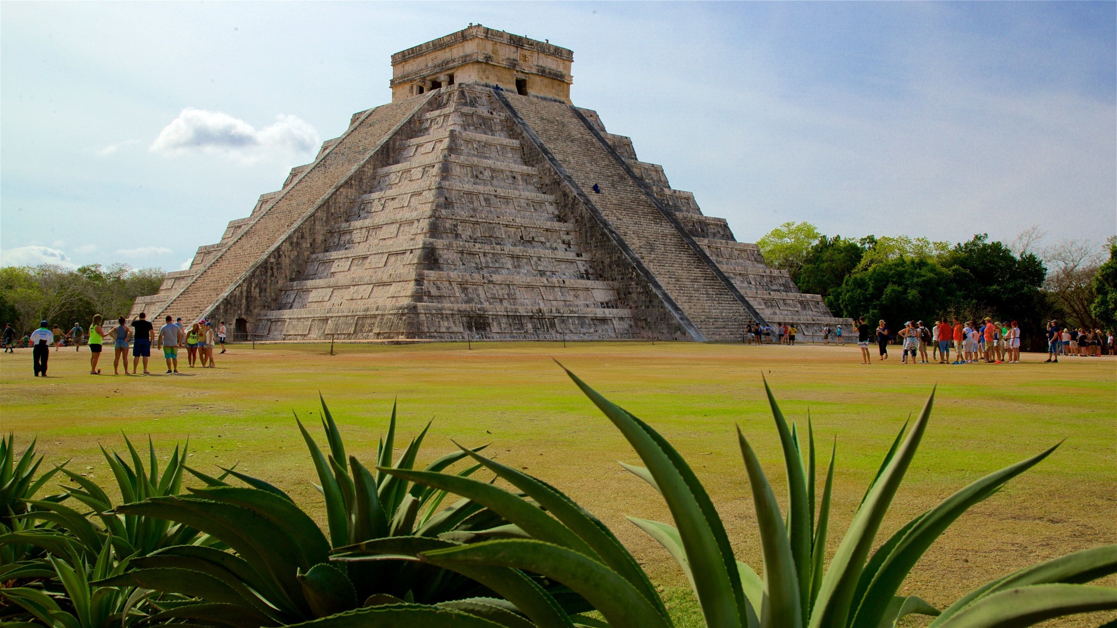 Pyramid of Kukulkan which includes heritage architecture and a park as well as a small group of people