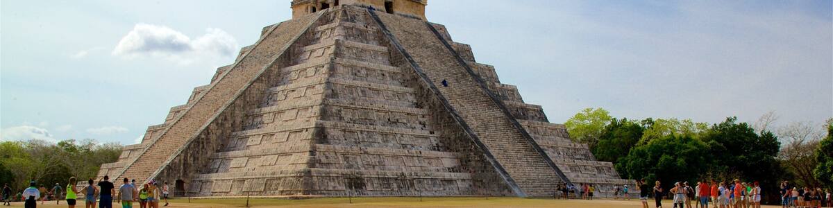 Une grande pyramide entourée de touristes.
