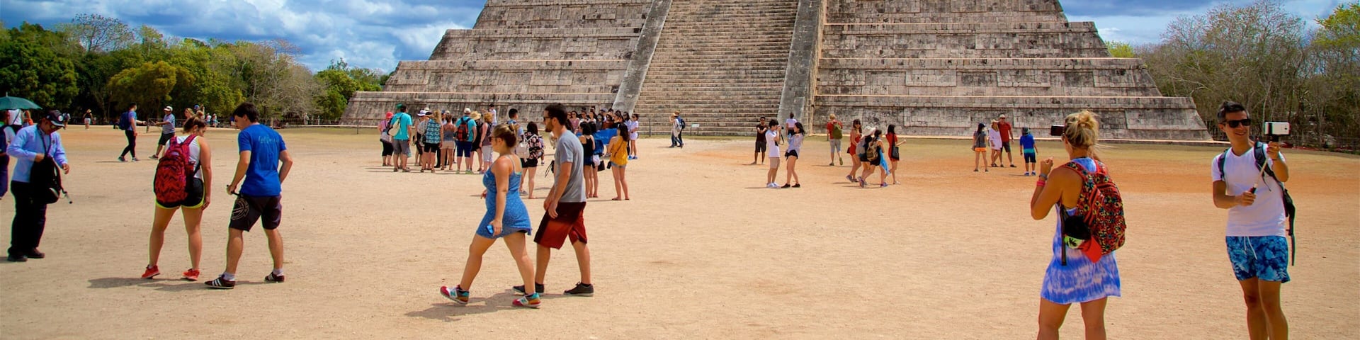 Pyramid of Kukulkan which includes heritage architecture as well as a small group of people