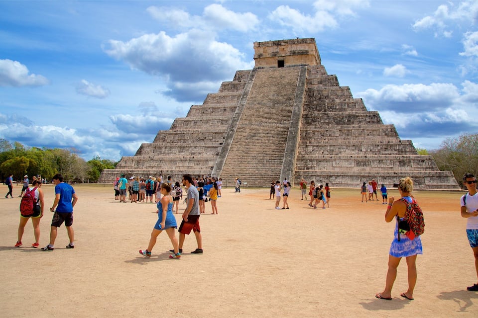 A large pyramid with tourists around it.