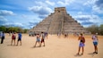 Kukulkanin pyramidi johon kuuluu vanha arkkitehtuuri sekä pieni ryhmä ihmisiä
