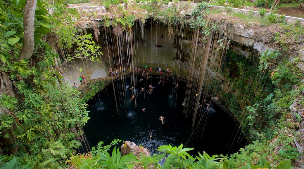 Cenote Ik kil featuring a lake or waterhole and swimming as well as a small group of people