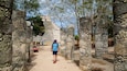 A historical site with stone ruins and a pathway leading to a distant structure.