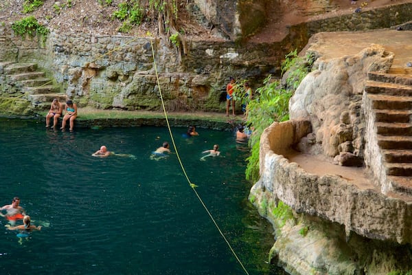 Cenote Zaci which includes swimming and a lake or waterhole as well as a small group of people