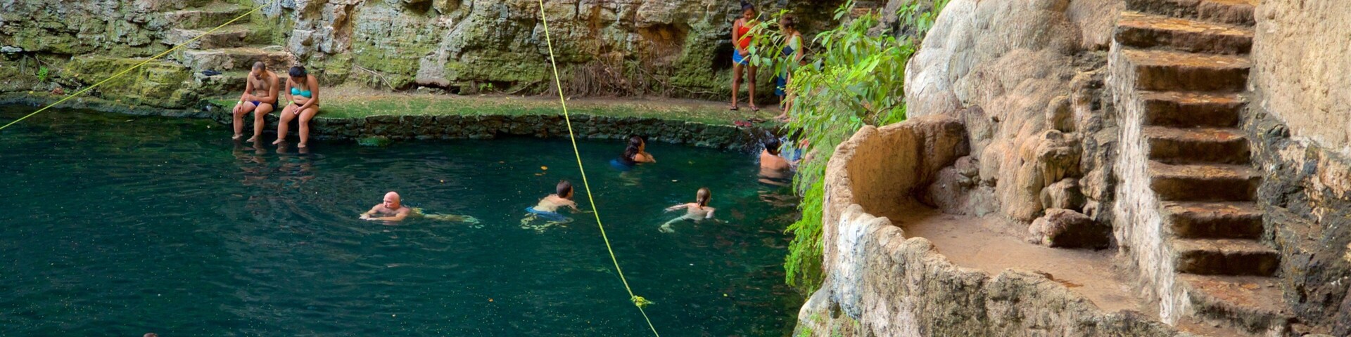 Cenote Zaci ofreciendo natación y un lago o laguna y también un grupo pequeño de personas