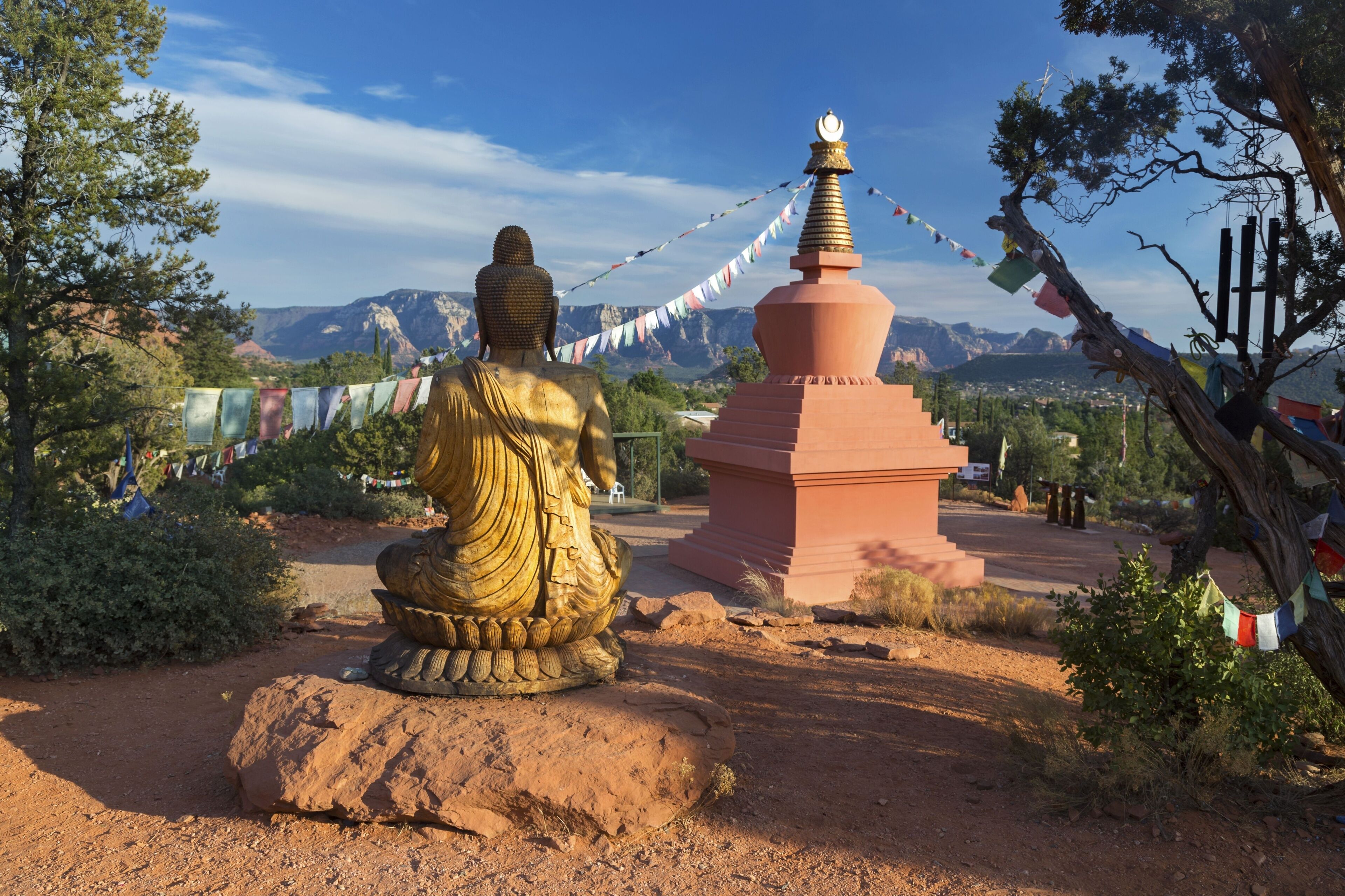 Amitabha Stupa, Buddha Statue and Prayer Flags with Distant Red Rock Landscape in Peace Park, Sedona Arizona