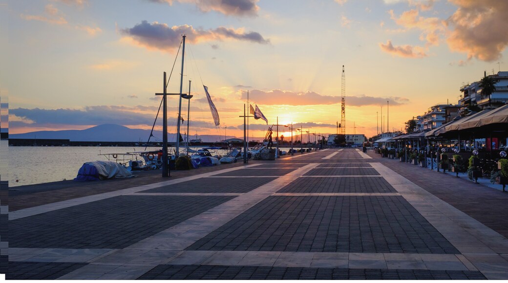 Dramatic sunset over yachts and boats moored at Kalamata harbor quayside, Peloponnese, Greece