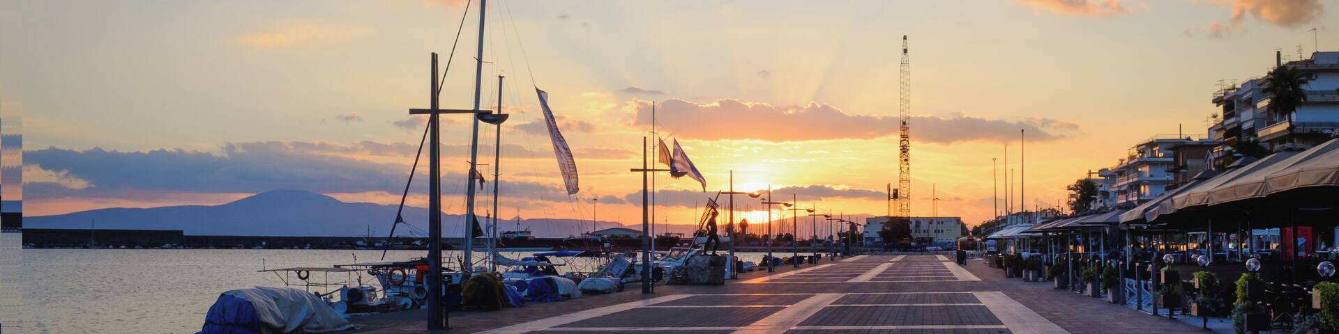 Dramatic sunset over yachts and boats moored at Kalamata harbor quayside, Peloponnese, Greece