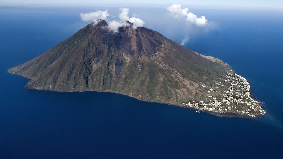 An island with a volcano, surrounded by deep blue ocean.