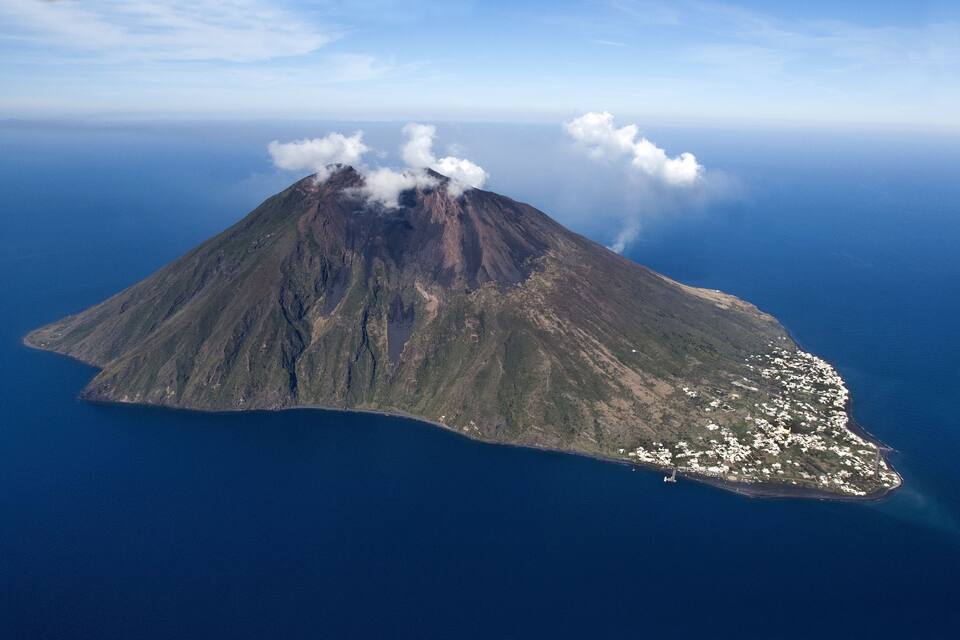 Uma ilha com um vulcão, cercada por um oceano azul profundo.