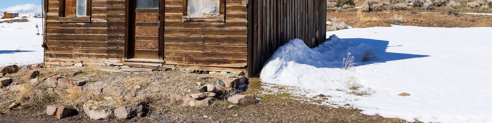 Old weathered Ghost Town buildings in the desert during winter with snow. Ione, Nevada