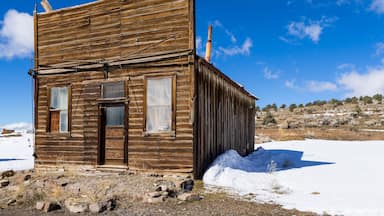 Old weathered Ghost Town buildings in the desert during winter with snow. Ione, Nevada
