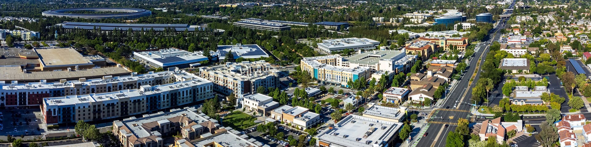 Aerial panoramic view of Main Street Cupertino residential and commercial neighborhood in San Francisco Bay Area, California. Silicon Valley skyline