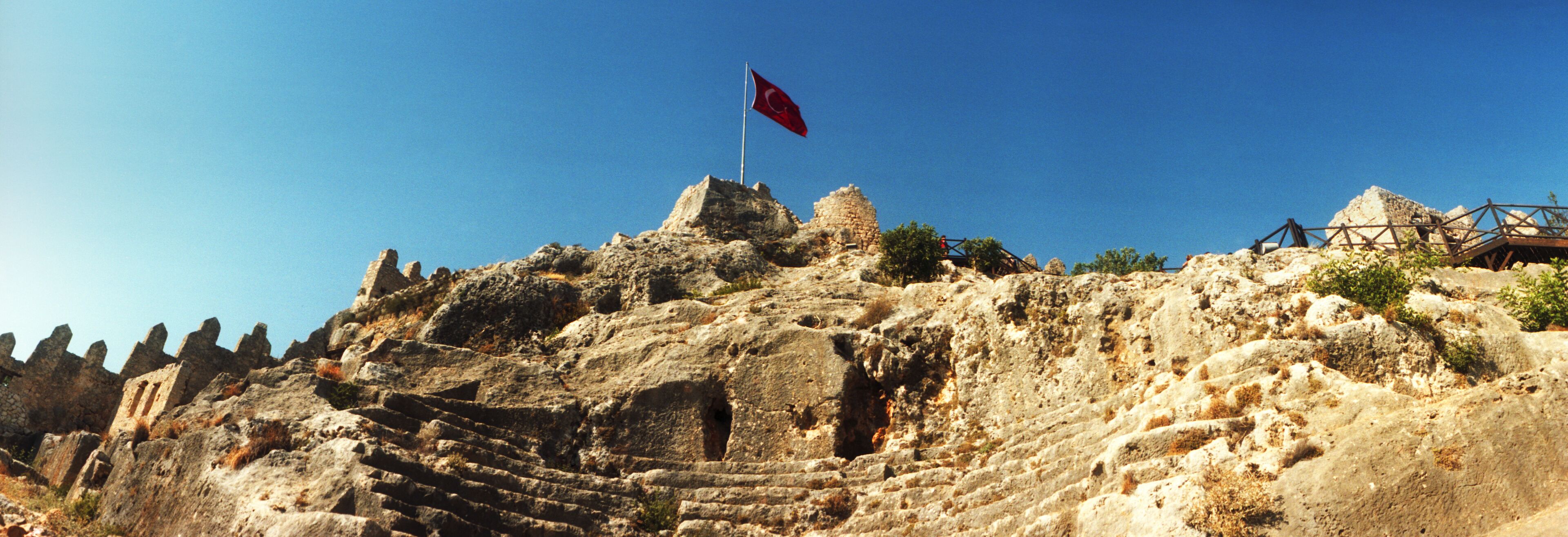 Panoramic view of Byzantine castle of Kalekoy with a Turkish national flag, Antalya Province, Turkey.