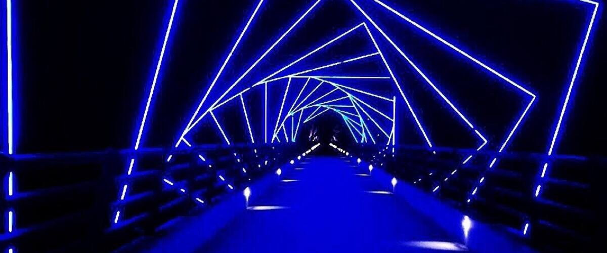 A tunnel with blue neon lights forming geometric patterns.