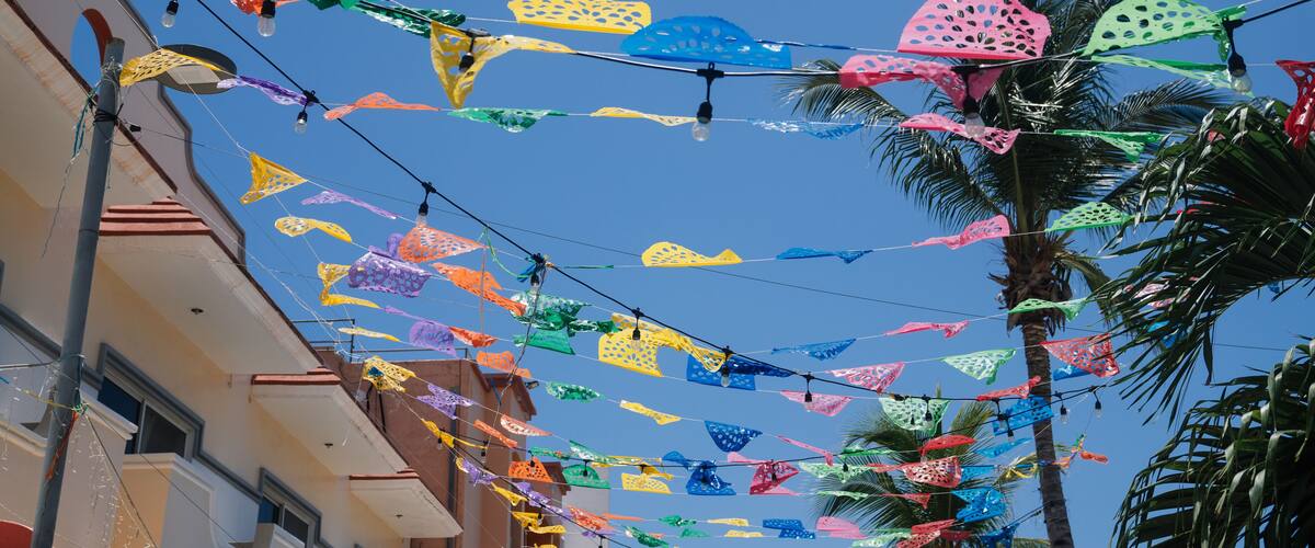 A street with colorful paper decorations hanging between buildings.