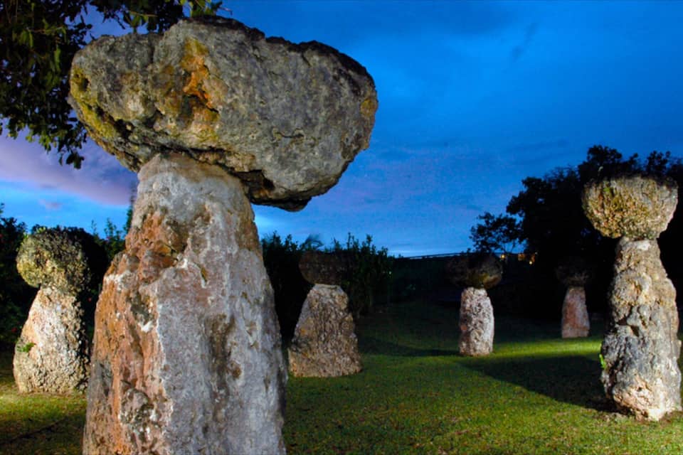 A stone circle with large upright stones and a smaller stone balanced on top of one of the upright stones.